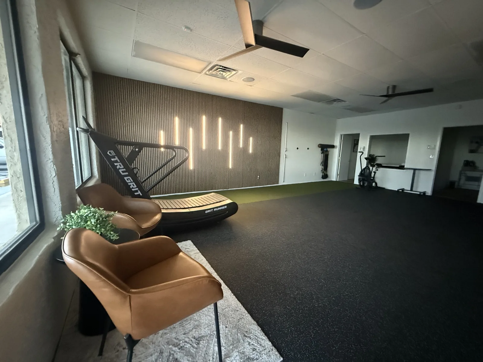 Treatment floor at Solas Physical Therapy, 300 N Resler Dr Ste F in west El Paso — open rubber floor, turf lane and acoustic slat wall
